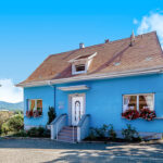 maison bleue dans un paysage bucolique pour illustrer le nettoyage des lieux proposés par O Coeur de l'Eau